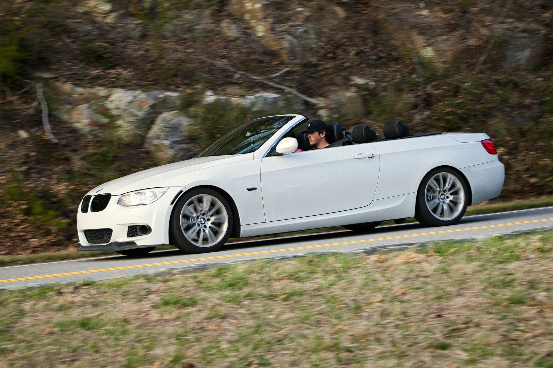 Baltas BMW kabrioletas važiuoja nuleistu stogu